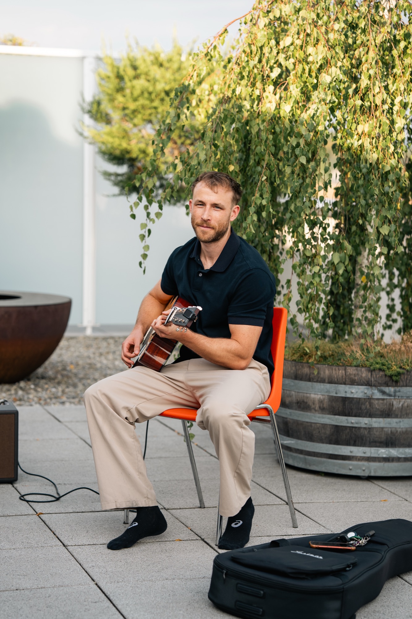 Elias playing acoustic guitar on a rooftop terrace